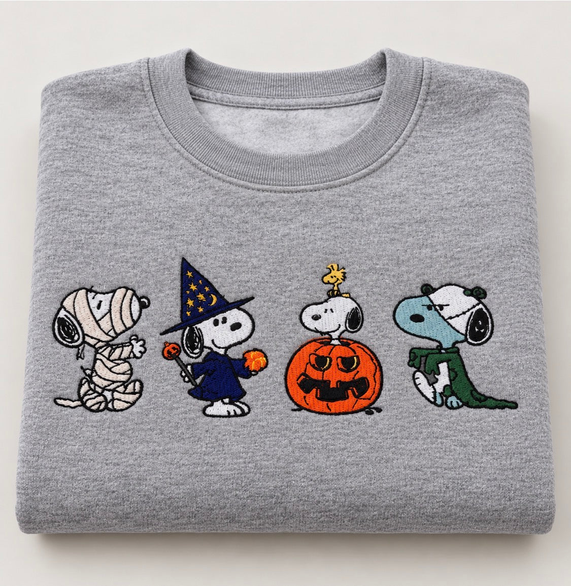 Athletic grey crewneck featuring an adorable dog embroidered in four Halloween costumes